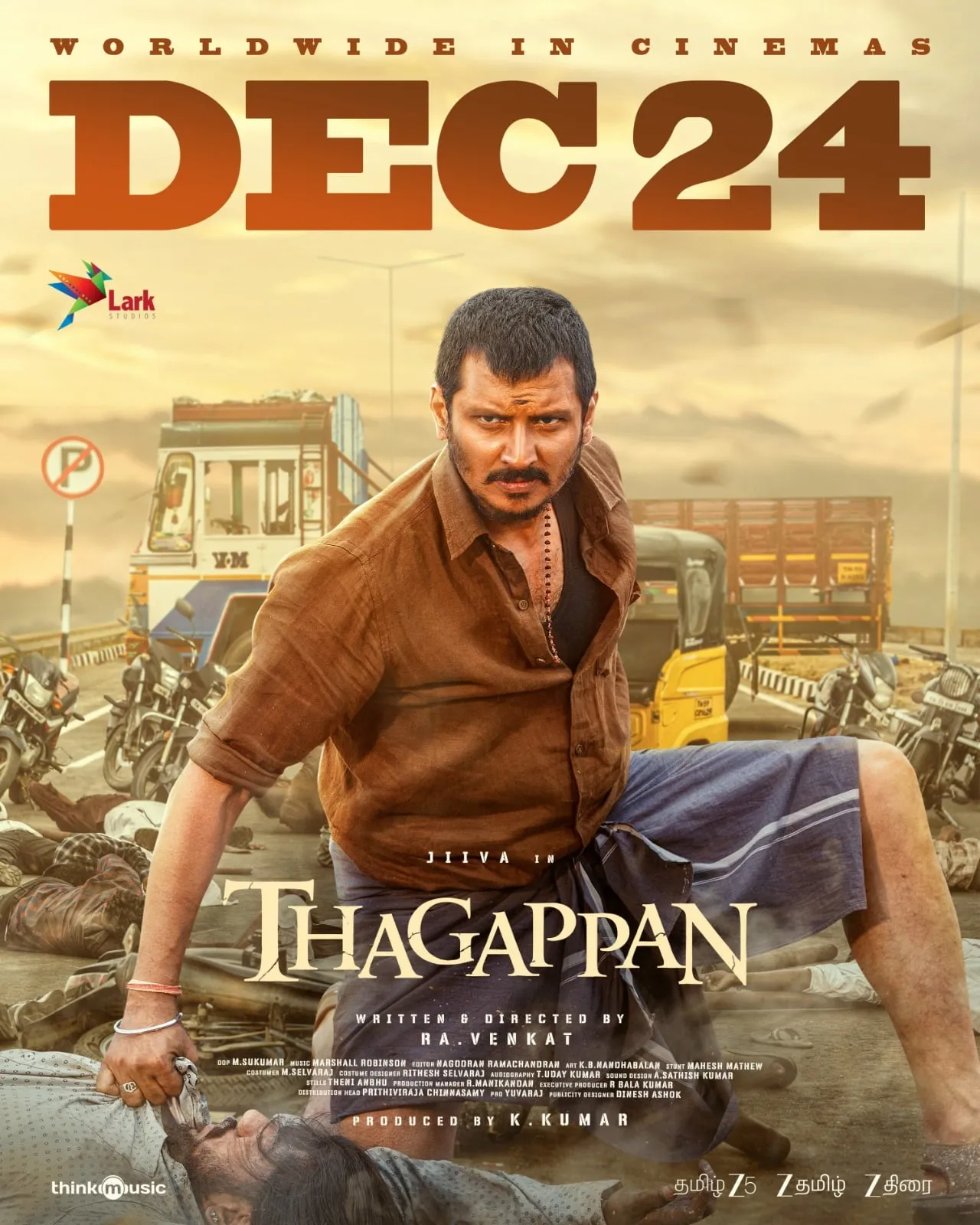 Jiiva in a brown shirt and blue lungi amid a street fight in the Thagappan December 24 release poster
