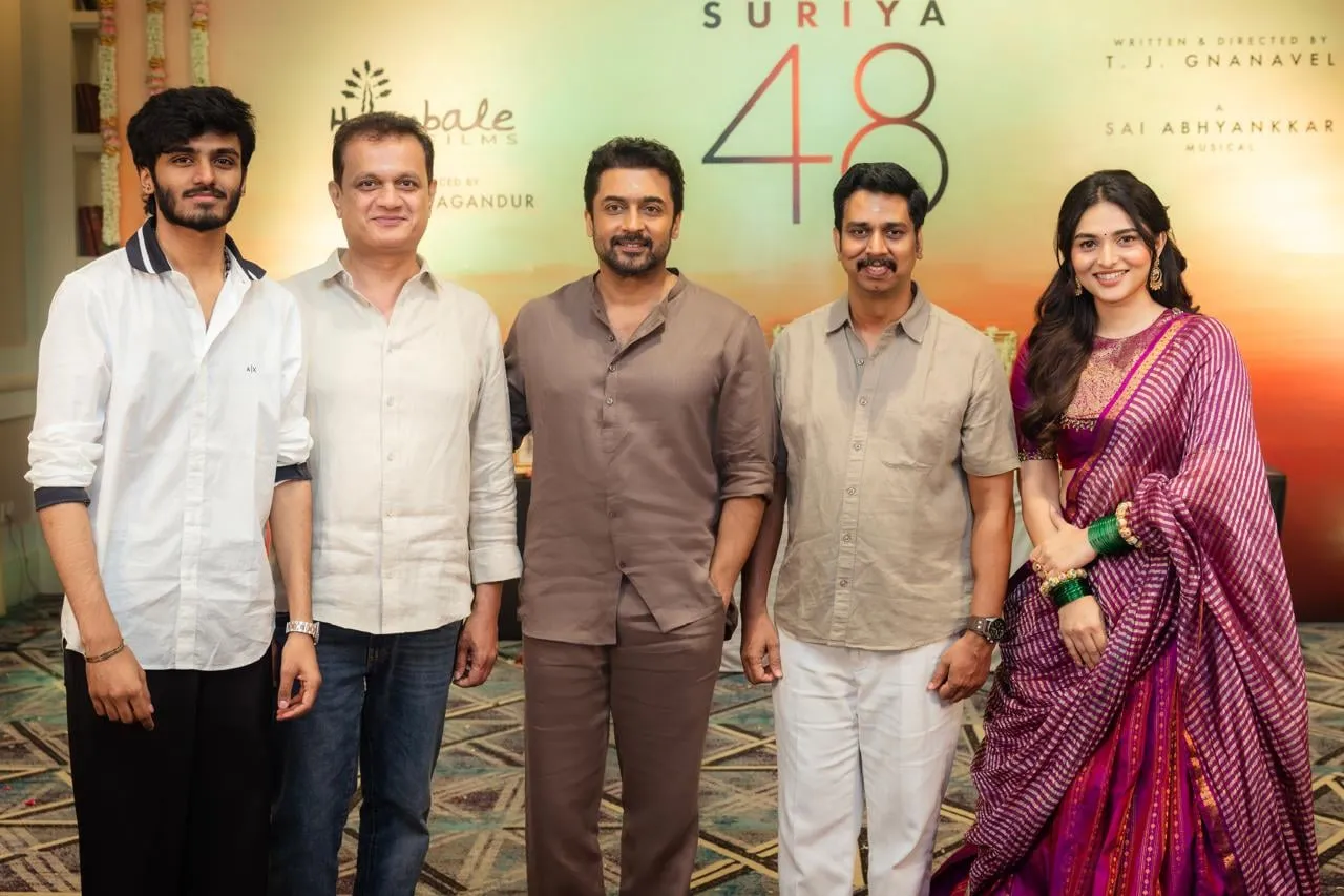 Suriya with the Suriya 48 team at the film's launch, under the title logo