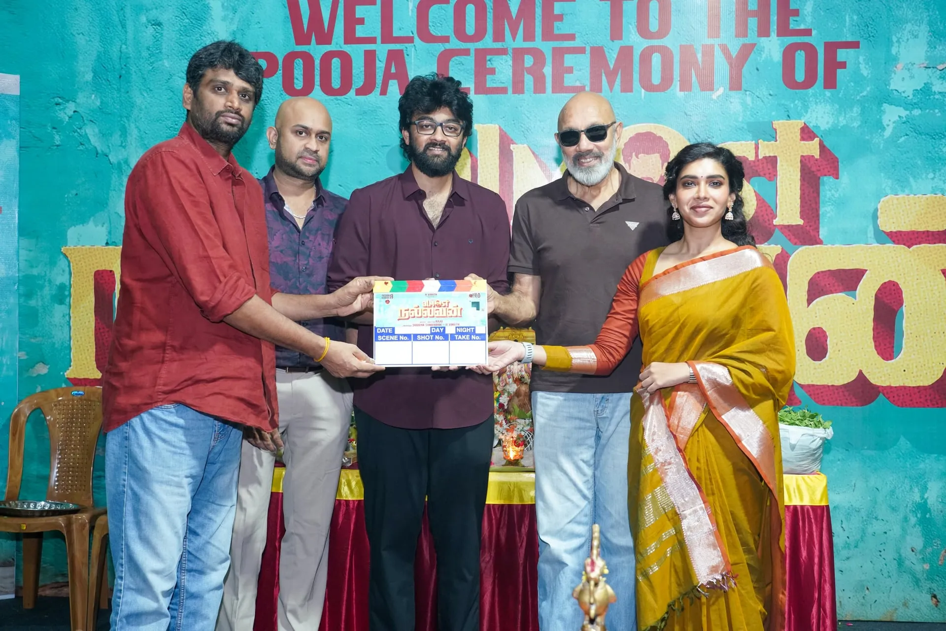 Raju Jeyamohan holding the clapboard with Sathyaraj, Dushara Vijayan and the producers at the Almost Nallavan launch