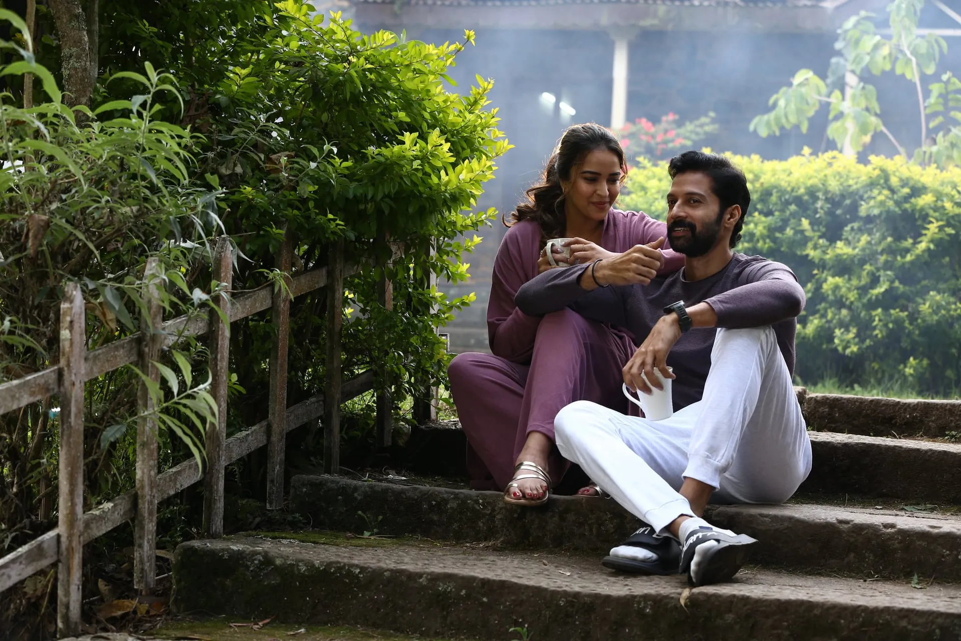 Santhosh Prathap and his co-star sitting on garden steps in a still from Signal at 11.30