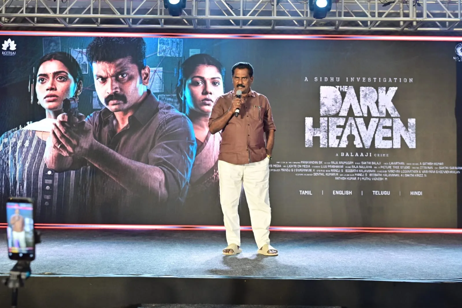 The Dark Heaven team at the trailer and songs launch, with the film's poster behind the stage