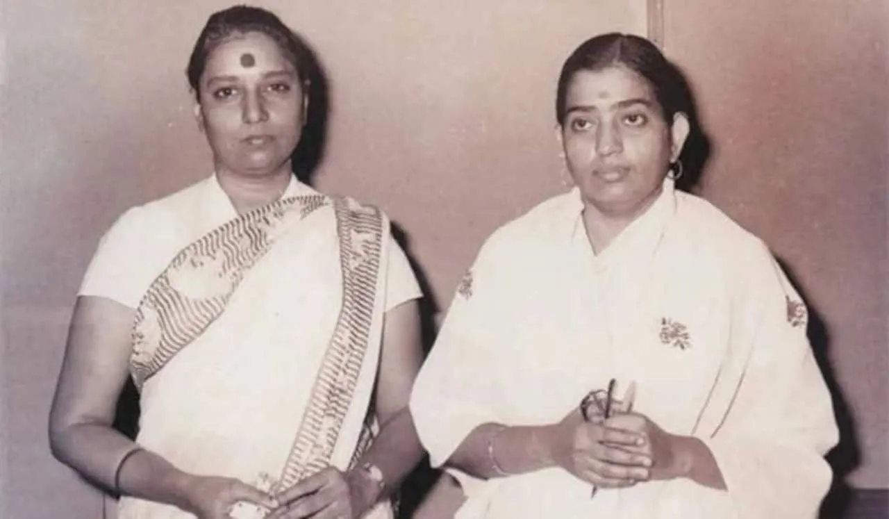 Archival photo of S. Janaki standing with fellow playback singer P. Susheela