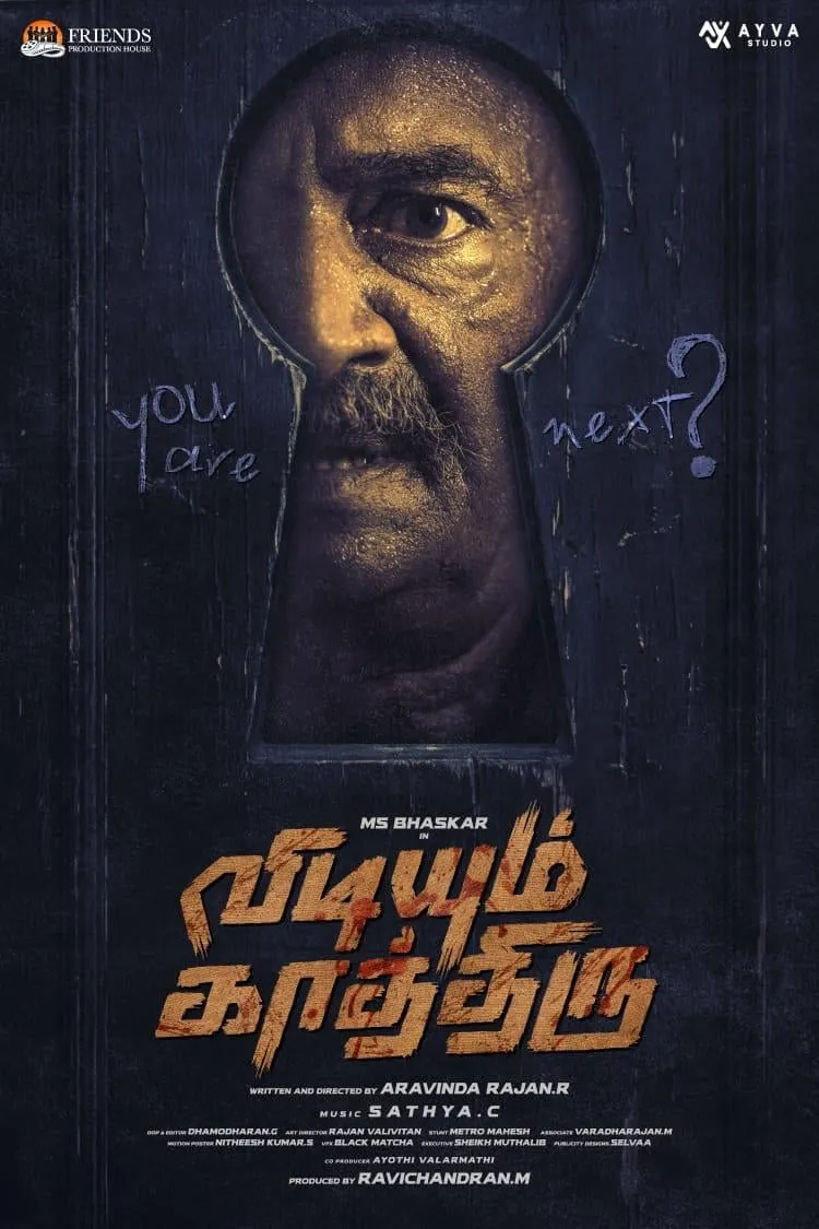 The first look frames M.S. Bhaskar through a keyhole, with a chalked warning scrawled across the door. Vidiyum Kaathiru first look poster with M.S. Bhaskar seen through a keyhole