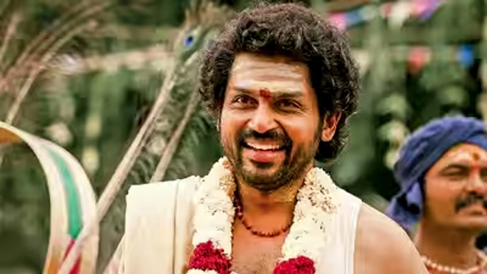 Karthi appears in traditional attire and a flower garland in a still from Sardar 2.