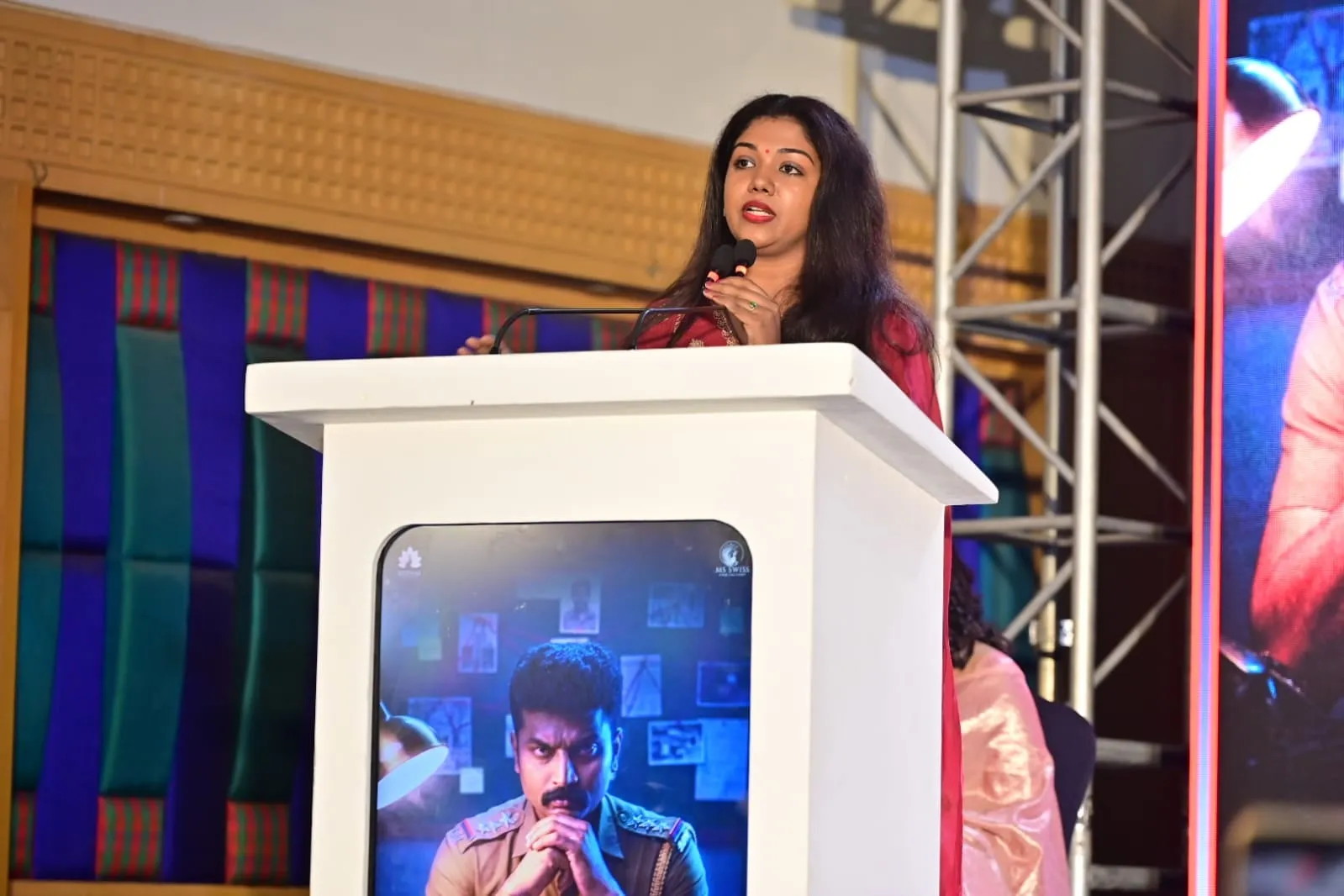 The film's poster looms behind a speaker at The Dark Heaven launch in Chennai