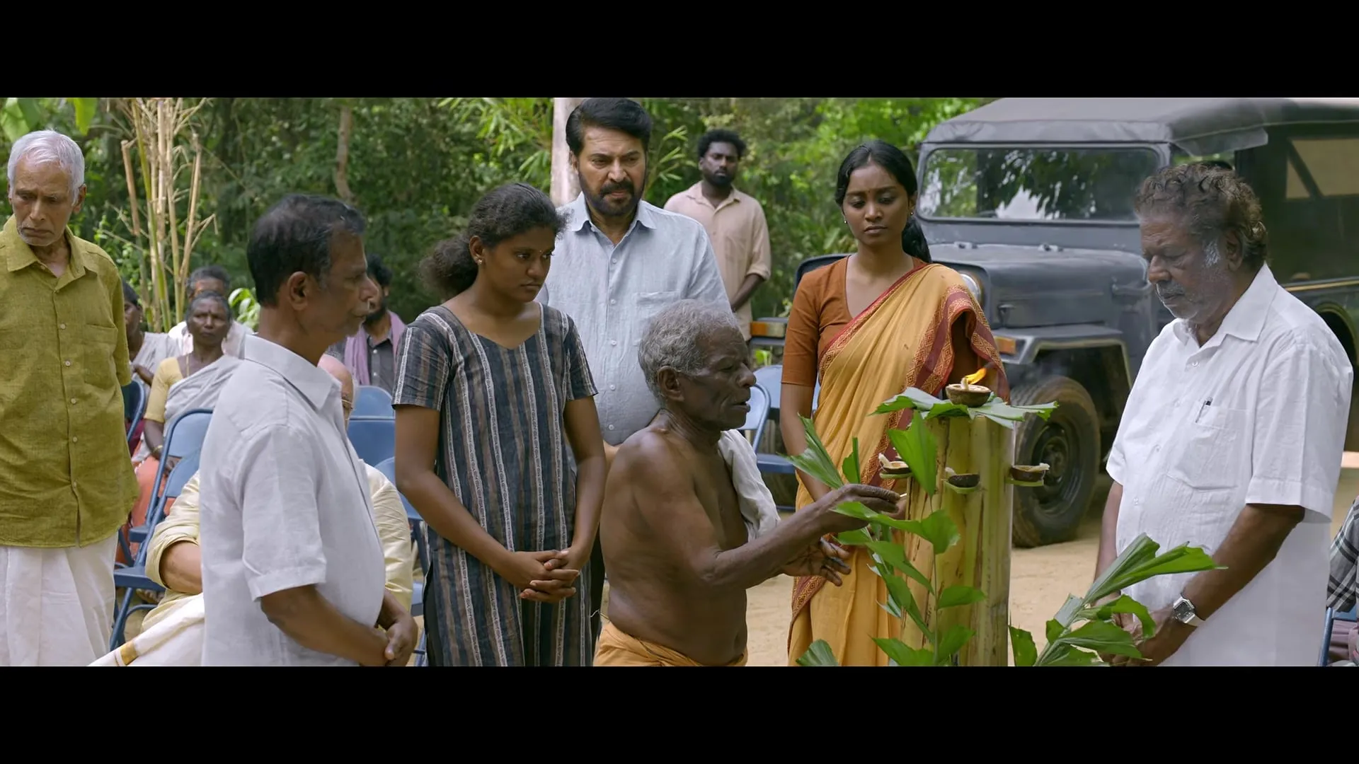 Villagers gather around a man holding a sapling outside a house in the Padayaatra trailer