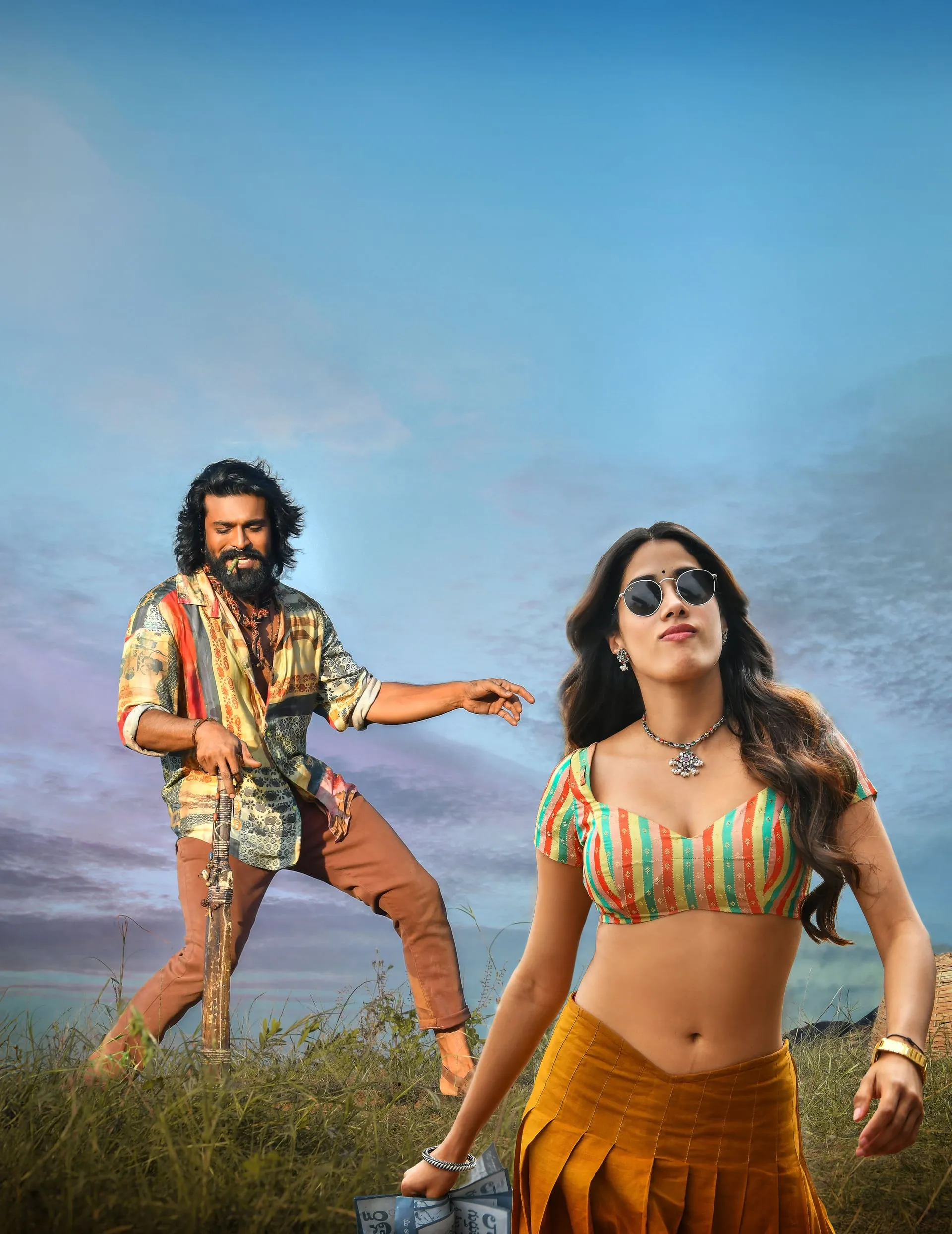 Ram Charan and Janhvi Kapoor strike a stylish pose in a Peddi still, bat in hand against an open sky