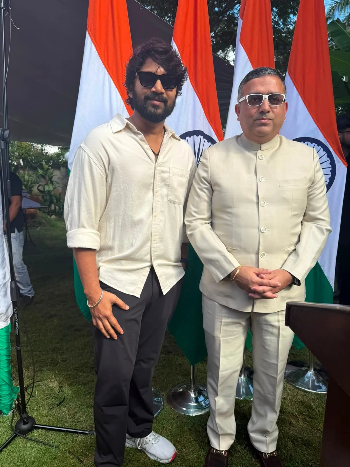 Vijay Vishwa with the Indian High Commissioner in front of a row of Indian flags in Malaysia