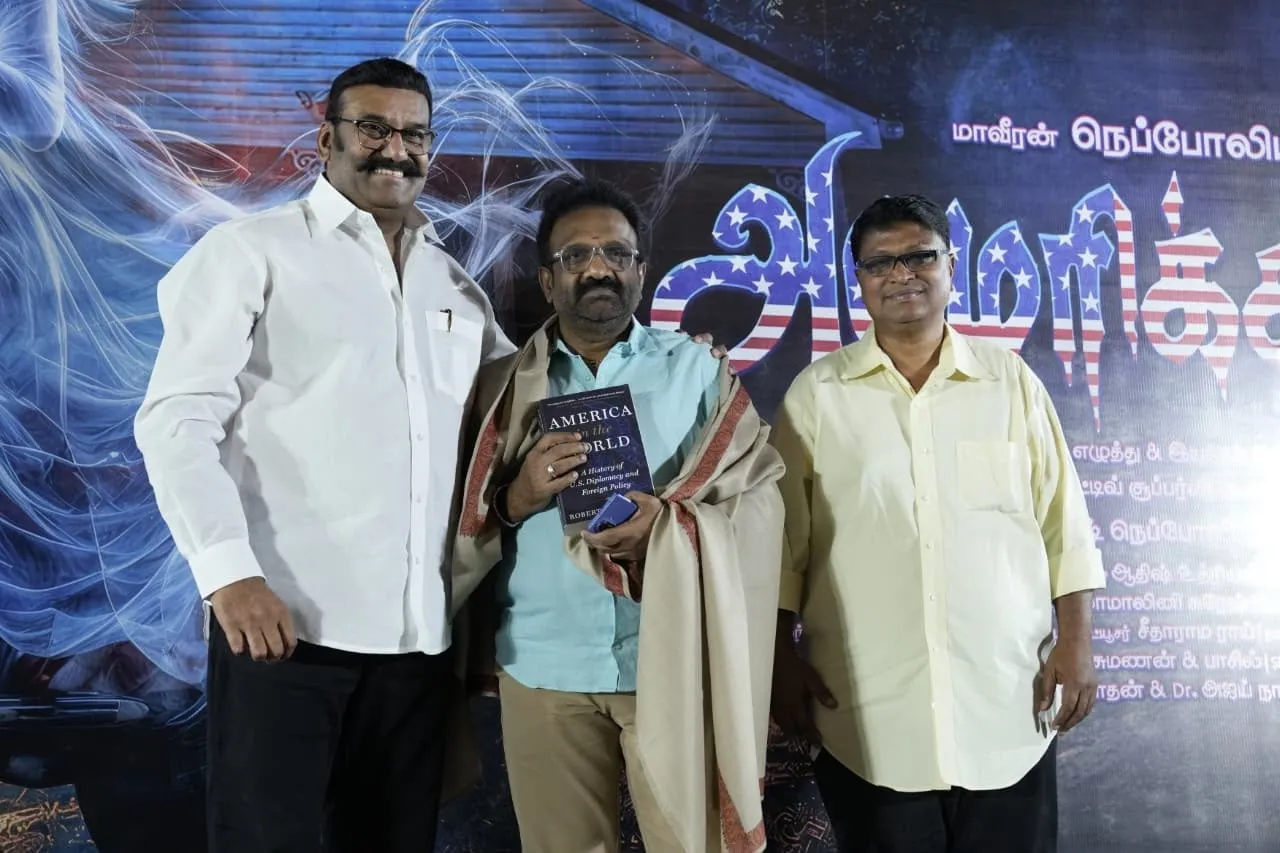 Napoleon presents a book to a guest on stage at the America Aavi launch